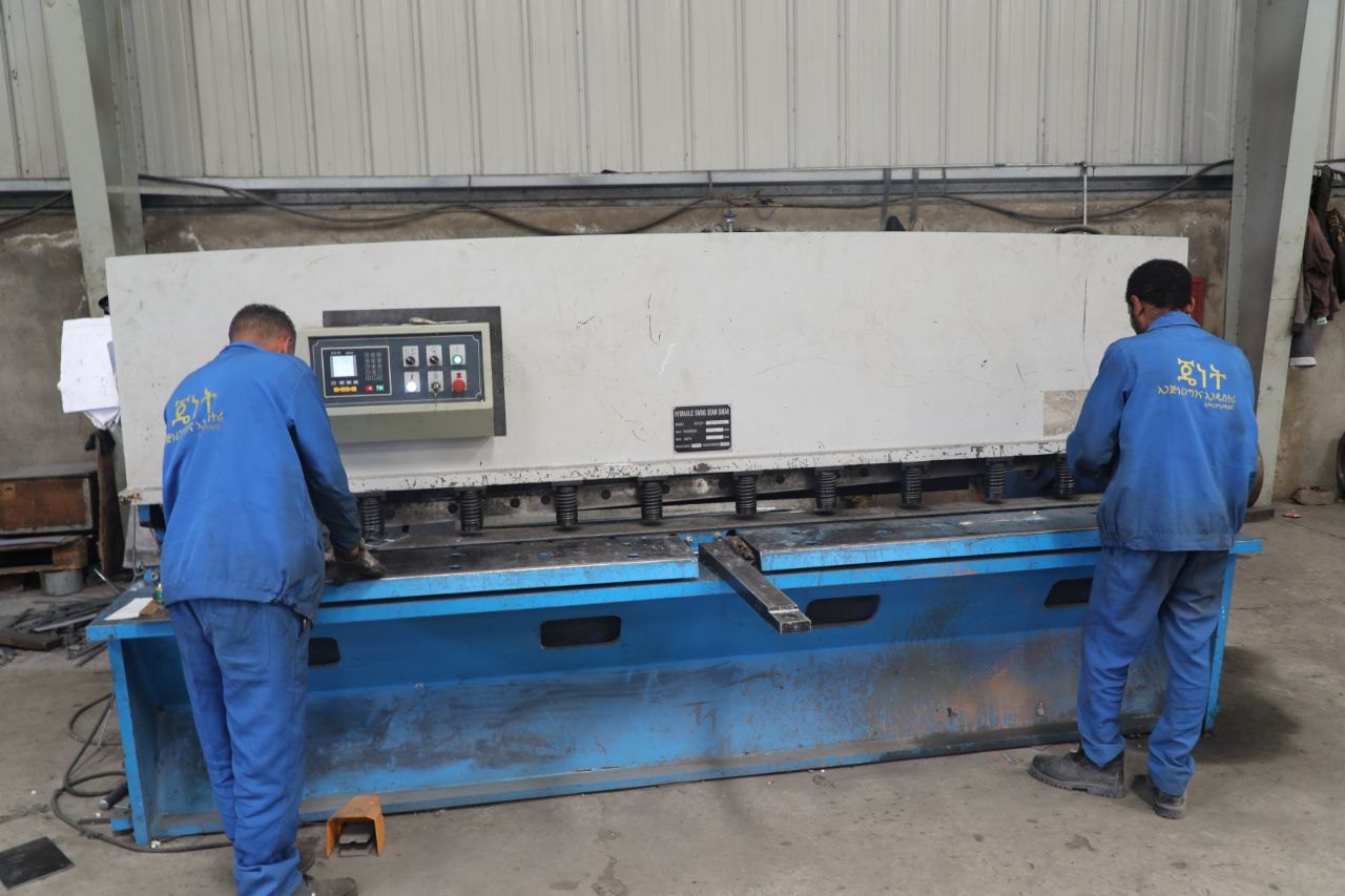 Workers operating fabrication machinery
